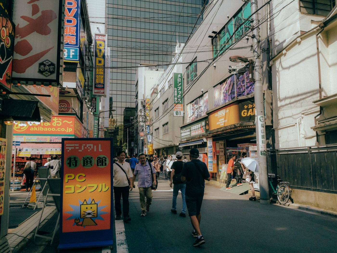 A vibrant street scene in Akihabara, Tokyo, showcasing modern architecture and lively crowd.