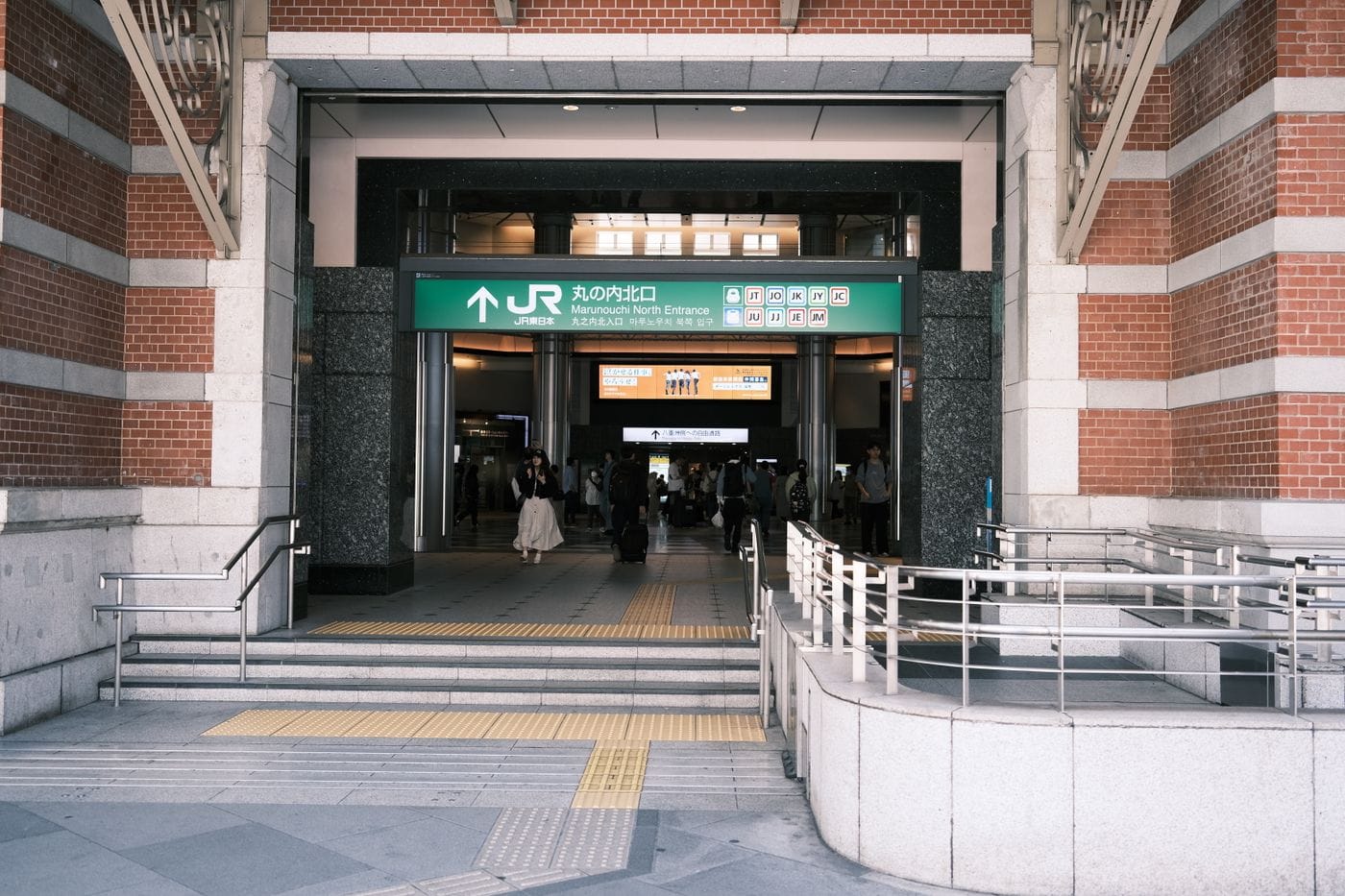 Entrance to Tokyo Station's Marunouchi North Entrance with people and signage visible.