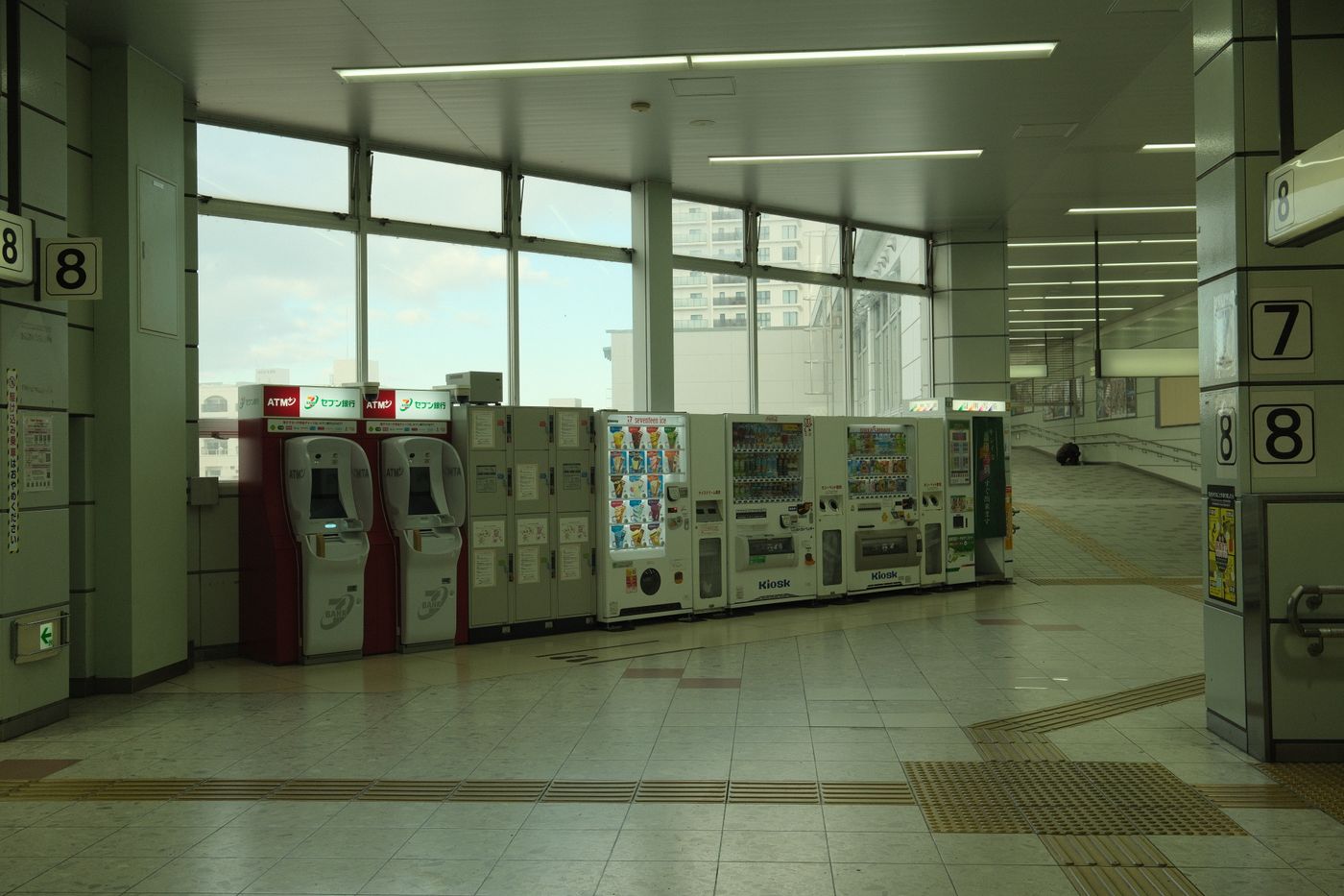 Spacious train station interior in Toyohashi, Japan with vending machines and ATMs.