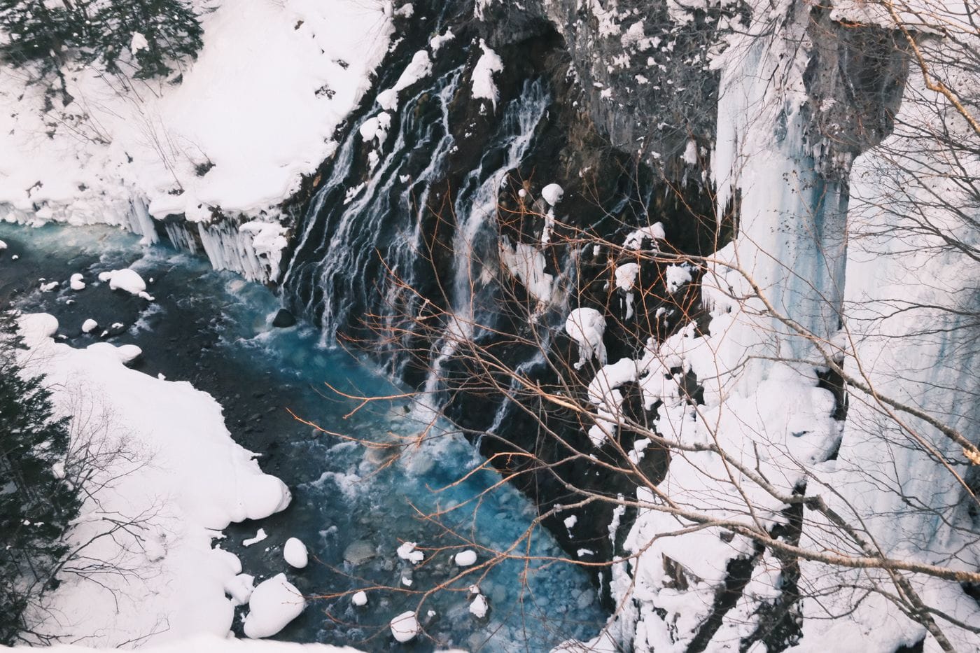 Stunning winter view of a frozen waterfall and stream in Biei, Hokkaido.