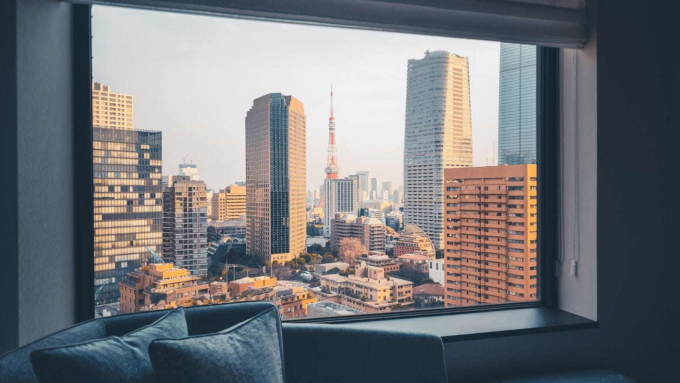 Captivating cityscape of Tokyo with Tokyo Tower framed by a hotel window, highlighting modern architecture.
