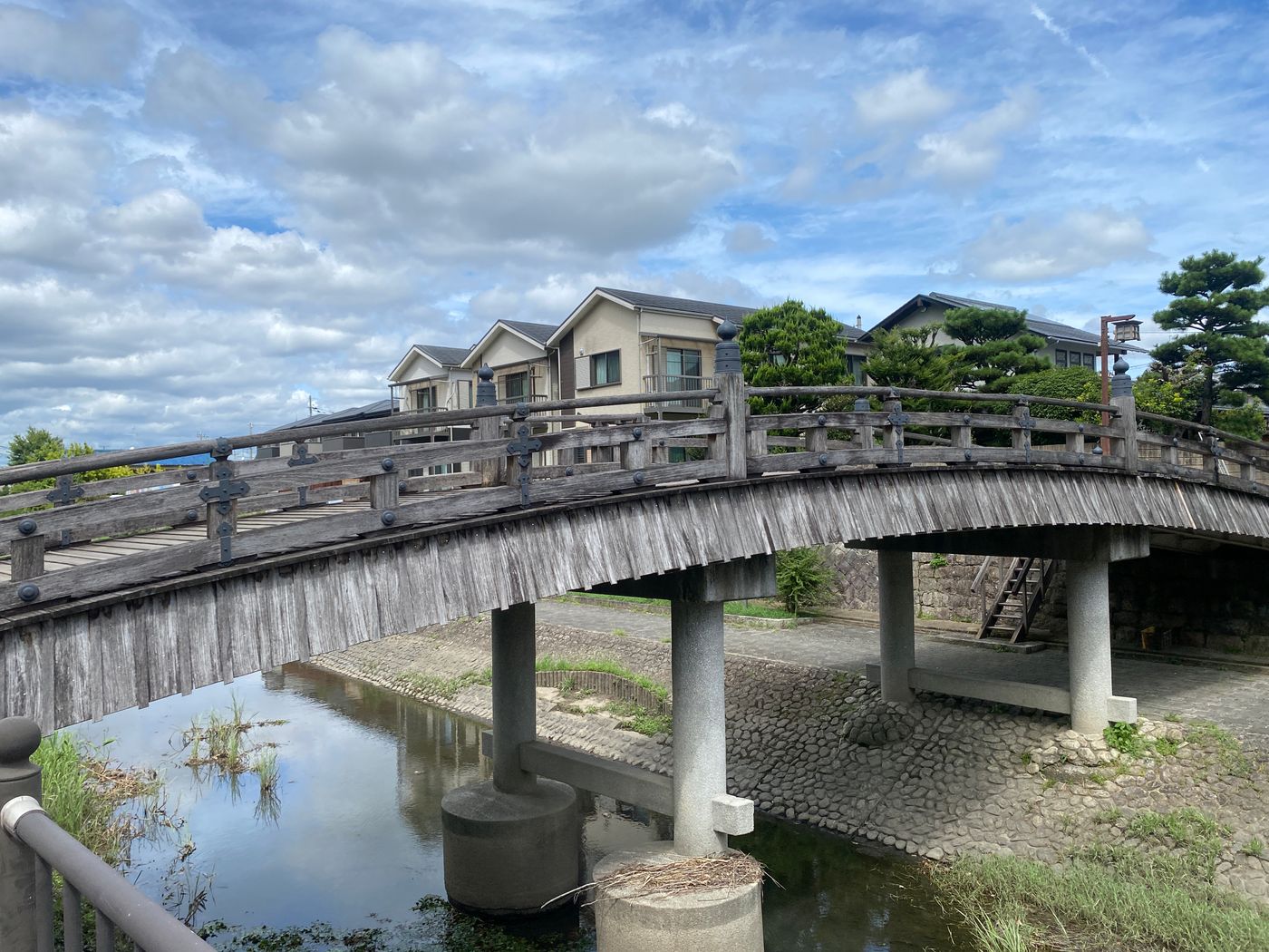 Scenic view of a wooden bridge over a canal in rural Japan, capturing the serene landscape.
