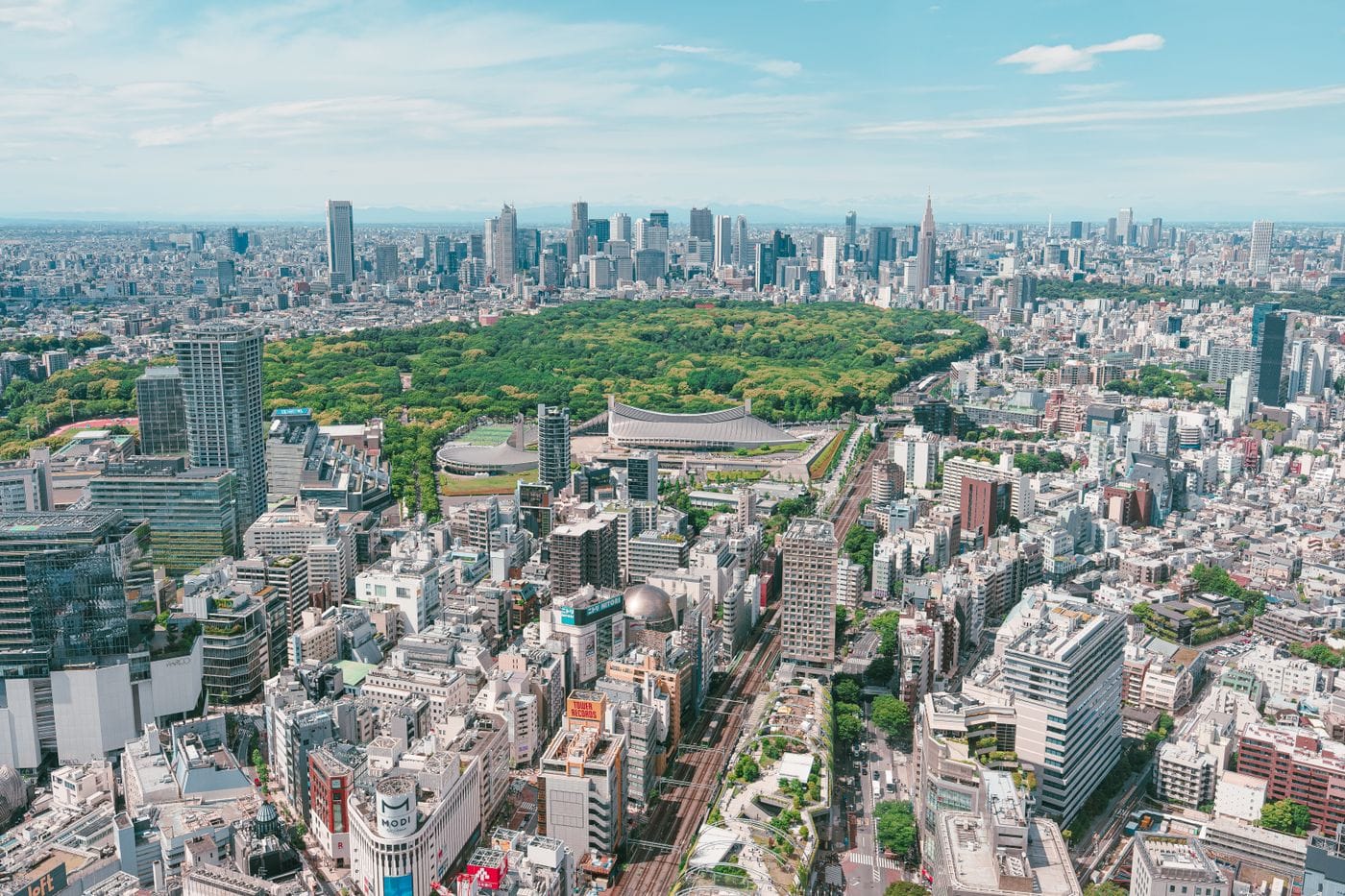 Stunning aerial perspective of Tokyo's urban landscape with lush Yoyogi Park in the foreground.
