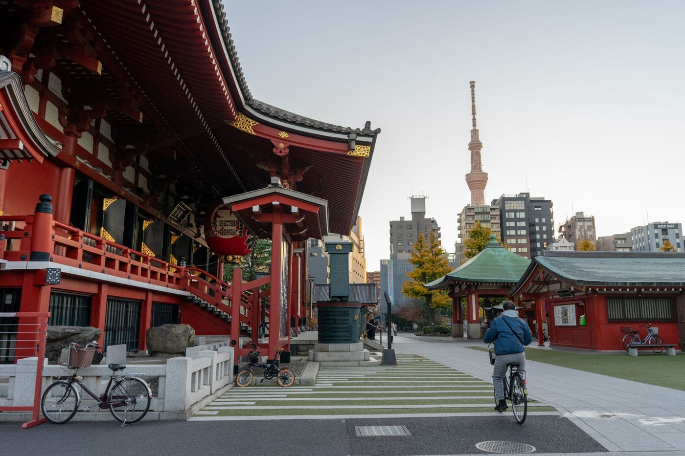 A cyclist near Senso-ji Temple in Tokyo with a view of the Tokyo Skytree in the background.