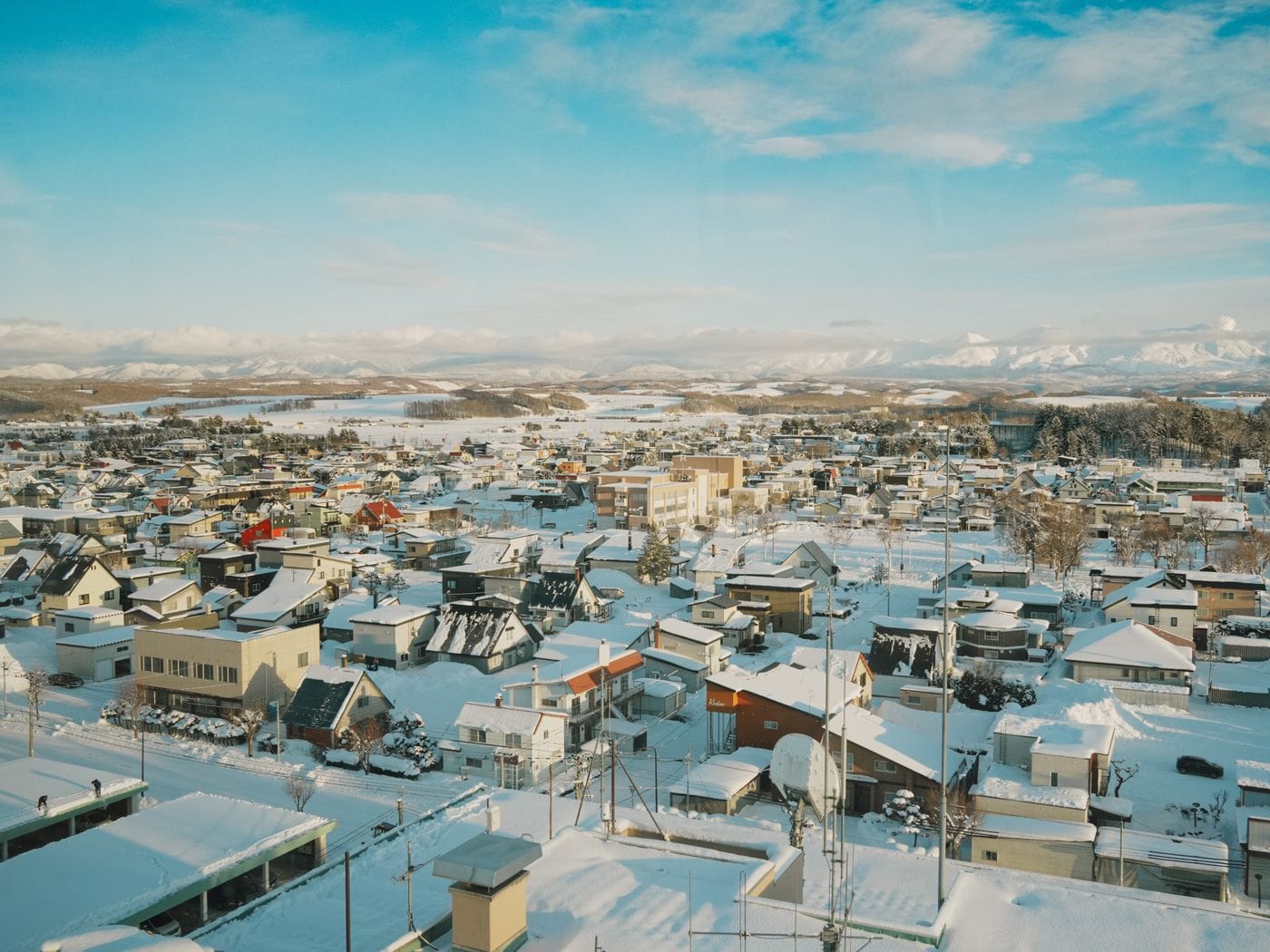 Scenic aerial view of a snow-covered town in Hokkaido, Japan during winter.