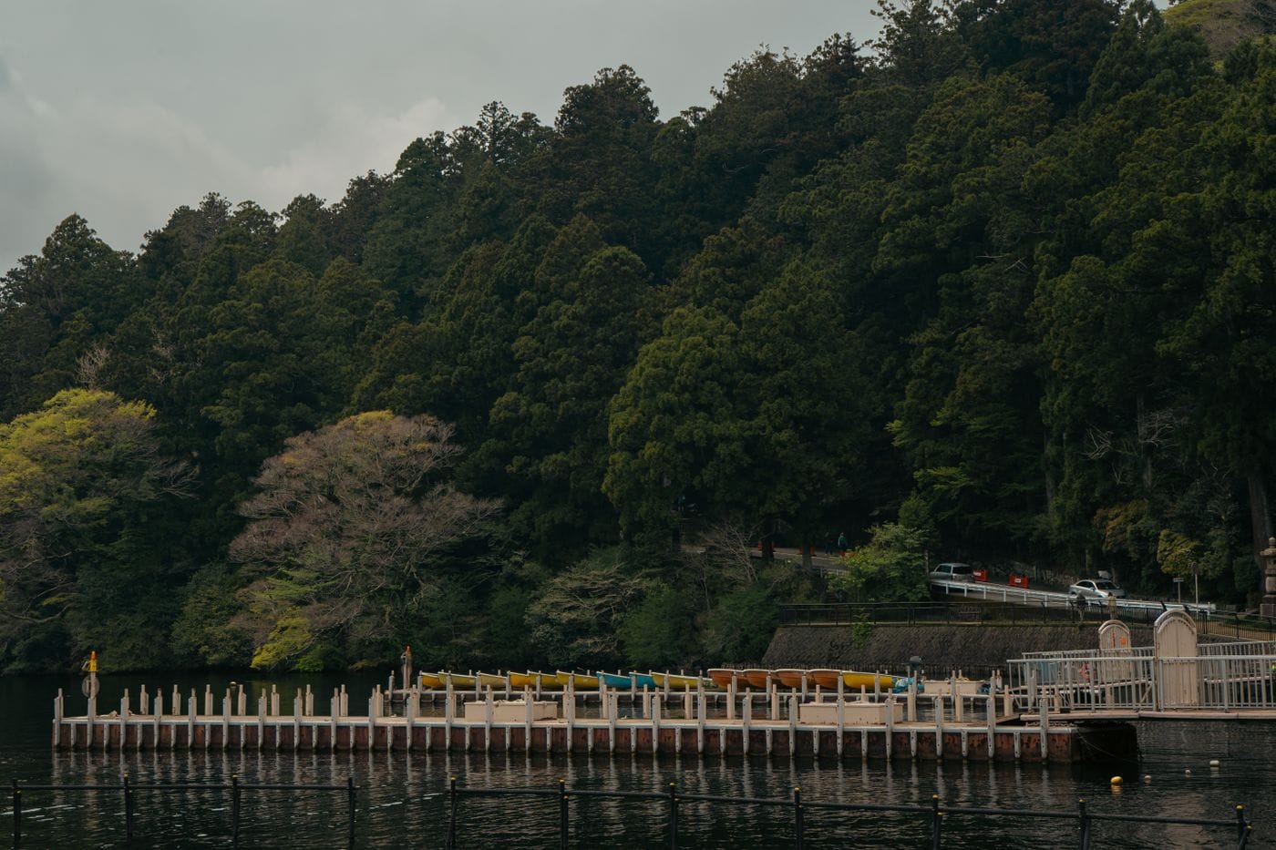 Serene view of the pier and dense forest along Lake Ashi, Hakone, Japan.