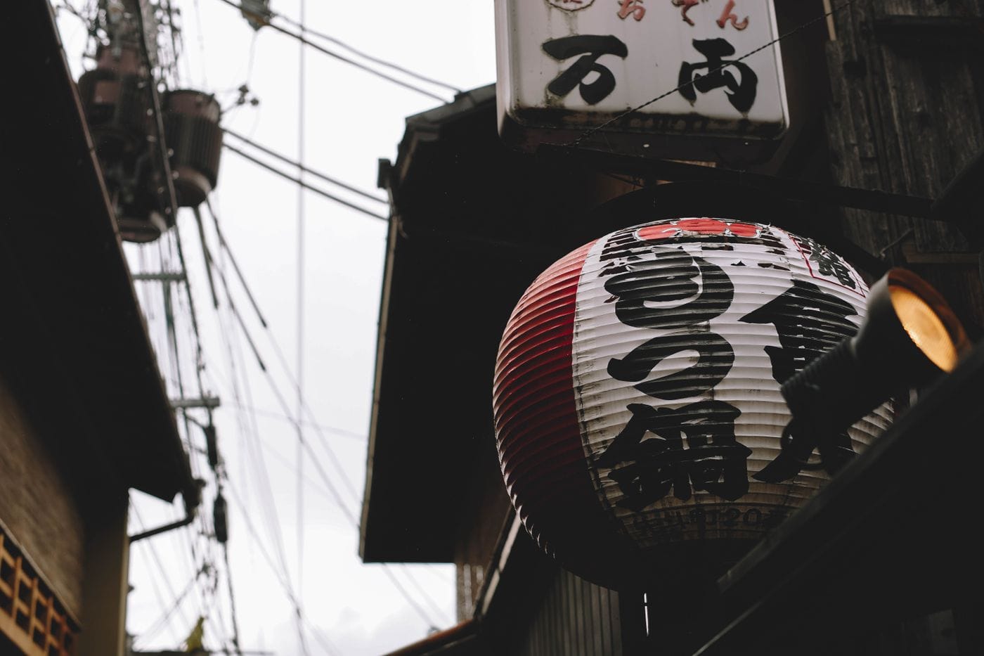 A close-up of a Japanese lantern in a street setting, capturing urban ambiance.